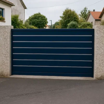 Portal de aluminio corredera Modelo Silgar en color azul noche RAL 5011 con líneas inox, instalado en la entrada asfaltada de una vivienda en Pontevedra
