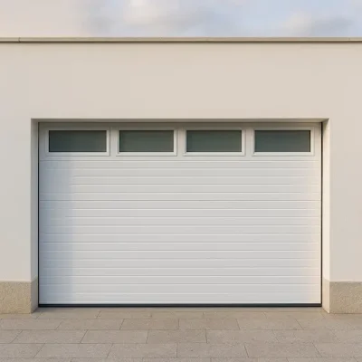 Puerta de garaje seccional blanca, panel acanalado y cuatro ventanas horizontales superiores, sin puerta peatonal, integrada en fachada de revoco blanco en vivienda de Galicia.